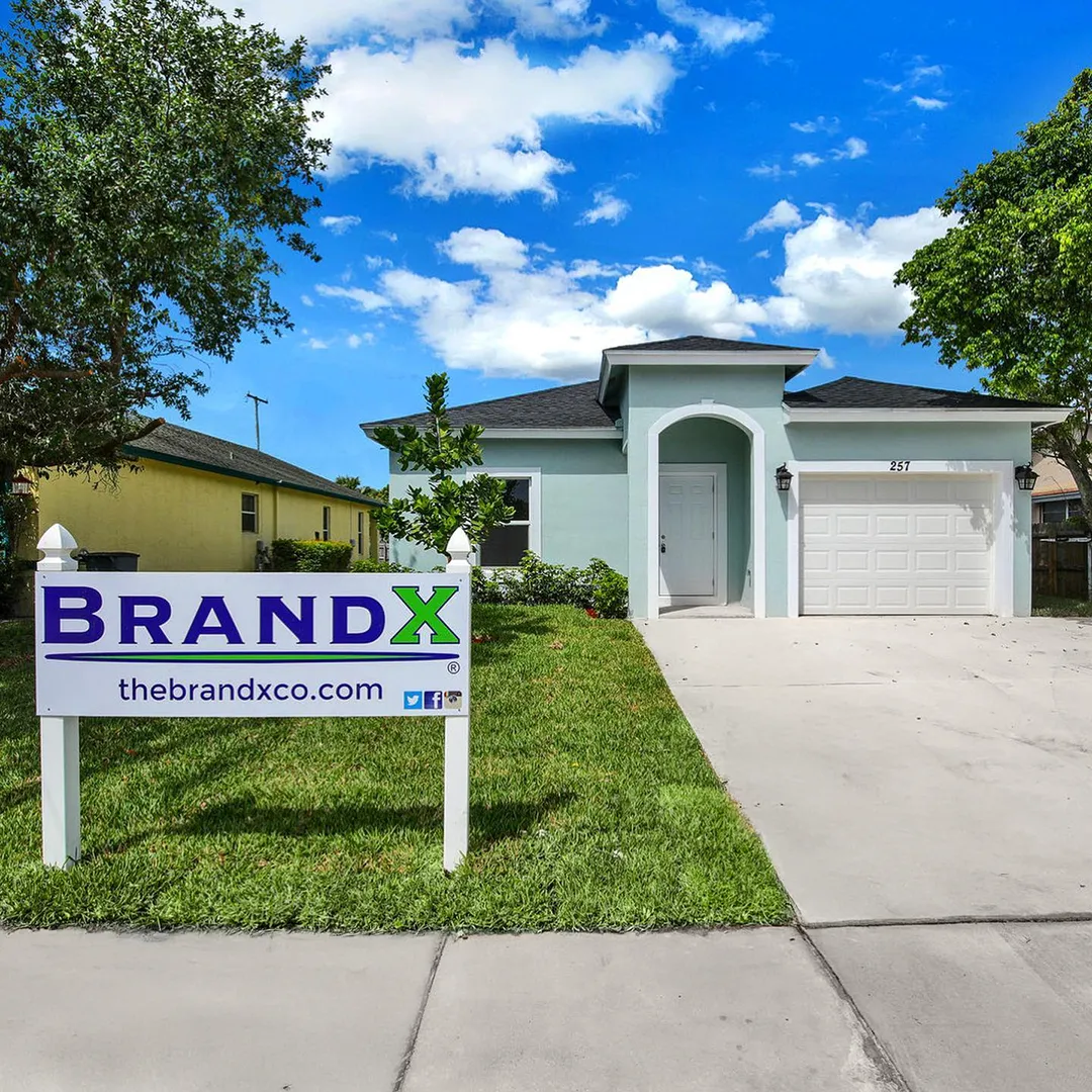 House with sign by BrandX in the front lawn.